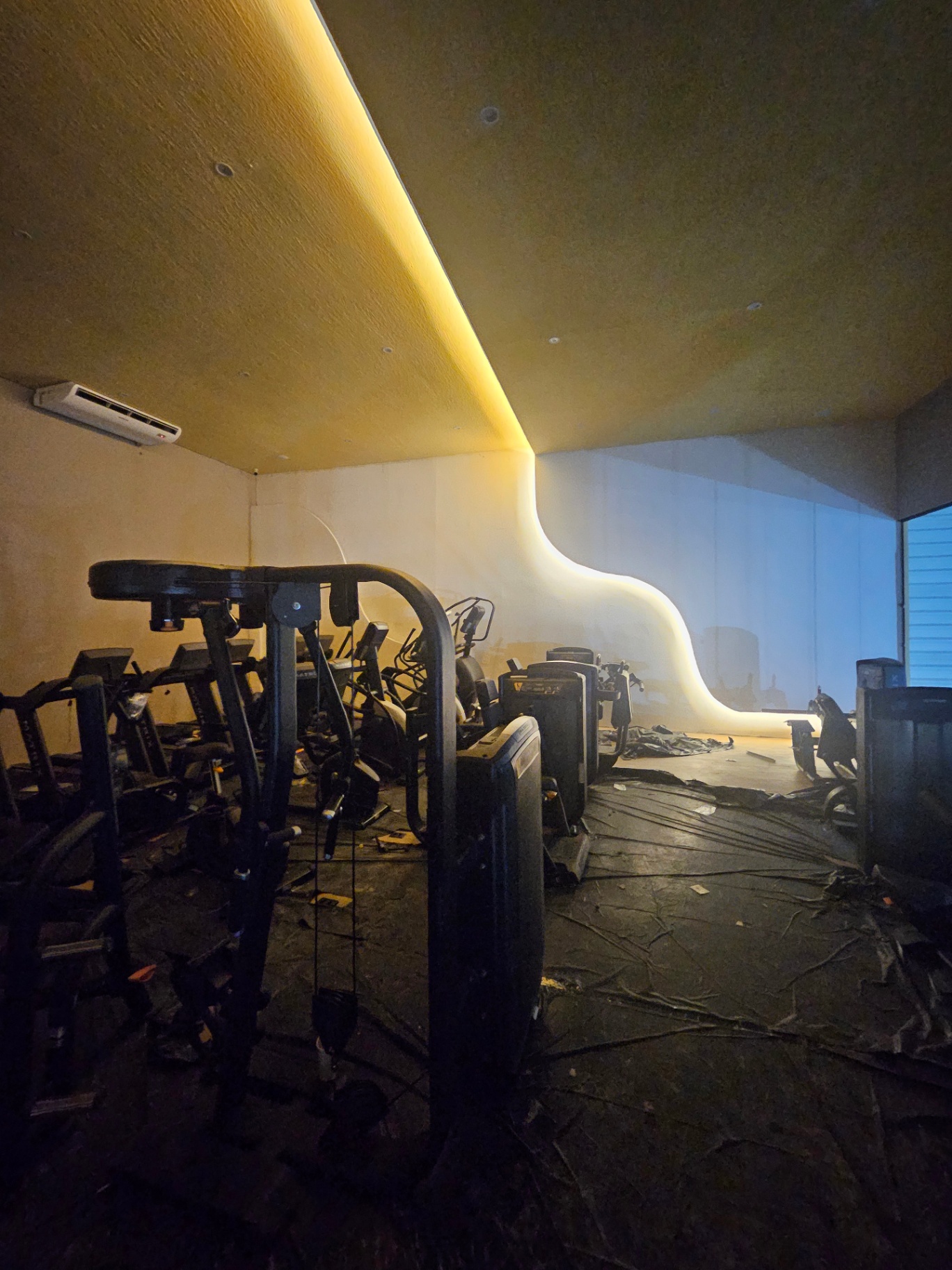 Sala de musculação de academia premium com sanca curva iluminada por LED quente